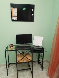 escritorio con ordenador y ordenador portátil en The Room Charming Urban Getaway, en Santiago de los Caballeros