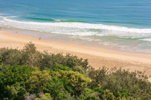 uma vista para uma praia com pessoas no oceano em 84 The Spit Holiday Apartments em Mooloolaba