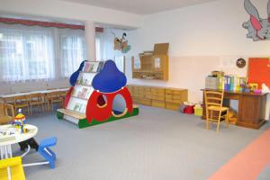 a room with a classroom with a play room with a toy house at Hotel Birkenhof am See in Sankt Kanzian