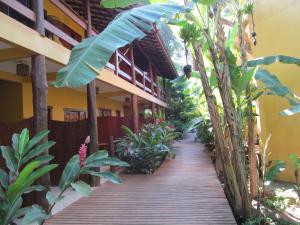 una pasarela de madera que conduce a un edificio con plantas en Pousada da Paz, en Itacaré