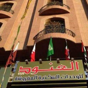 a sign in front of a building with flags at Al Anoud & Aljawhara Apartments in Hafr Al-Batin