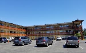 a parking lot with cars parked in front of a building at Nites Inn Motel in Seattle