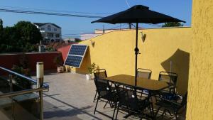 einen Tisch und Stühle mit Sonnenschirm auf einer Terrasse in der Unterkunft Vila Hestia in Constanţa