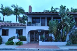 una casa blanca con palmeras delante en Casa Del Mar Inn, en Santa Bárbara
