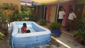 una niñita en una piscina inflable en un patio en Babylon Hotel & Serviced Apartment, en Dhaka