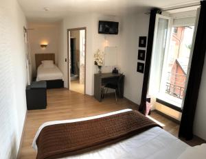 1 dormitorio con cama, escritorio y ventana en Hôtel du Château, en Alvignac