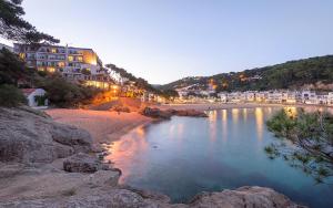 a view of a beach at night with buildings at Hotel Hostalillo by Escampa Hotels in Tamariu