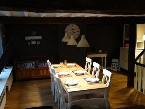 mesa de comedor con sillas y reloj en la pared en Huyze Peerdenbrugghe, en Brujas