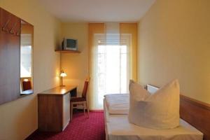 a hotel room with a bed and a desk and a desk at Gasthof zur Post in Höchstadt an der Aisch