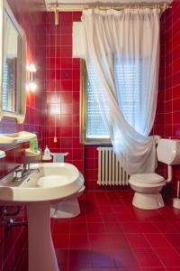 czerwona łazienka z umywalką i toaletą w obiekcie Florinda B&B Viareggio w Viareggio