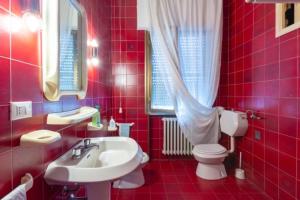 a red bathroom with a sink and a toilet at Florinda B&B Viareggio in Viareggio