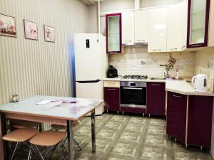 アドレルにある2 комнатные апартаментыのキッチン(テーブル、白い冷蔵庫付)