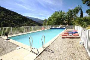 una piscina con 2 sillas de césped y sombrillas en La Clue/ le Jas du Ventoux, en Plaisians