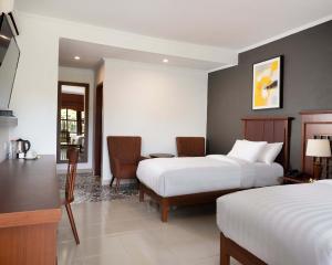 a hotel room with two beds and a table and chairs at Brits Resort Lovina in Lovina +66 photos