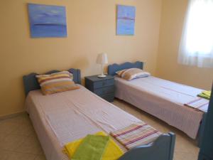 two beds sitting next to each other in a room at Sophies Apartments Ormos in Ormos Panagias