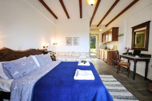 a large blue bed in a room with a desk at Gera's Olive Grove - Elaionas Lesvou in Perama