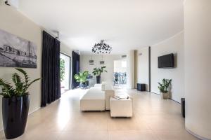 a living room with white furniture and potted plants at Boutique Hotel Bali in Lido di Jesolo