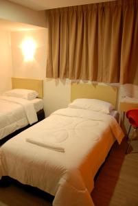 two beds in a room with a window at Old Penang Hotel - Penang Times Square in George Town