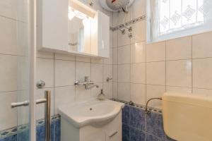 a white bathroom with a sink and a mirror at Apartments Janko in Rovinj +41 photos