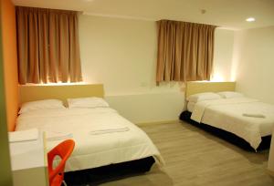 a hotel room with two beds and a table at Old Penang Hotel - Penang Times Square in George Town
