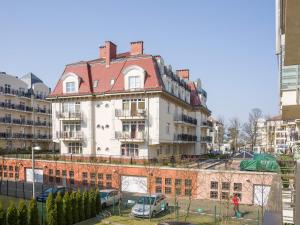 a large white building with a red roof at VacationClub - Villa Mistral Apartment 13 in Świnoujście