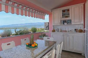 a kitchen with a table with a bowl of fruit on it at Apartment Klimno View Point in Klimno