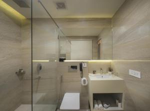 a bathroom with a shower and a toilet and a sink at 10 Park Street Hotel & Banquets in Gorakhpur
