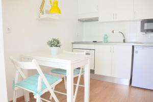Una cocina blanca con una mesa y sillas blancas. en Porto Garden Villas | Downtown, en Vila Nova de Gaia