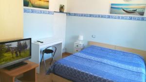 um quarto com uma cama azul e uma televisão em Affittacamere "In Piazzetta da Vasco" em Lerici
