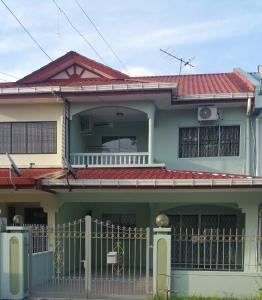 una casa verde con techo rojo en GuestHouse Taman Megah, Lot 19, en Sandakan