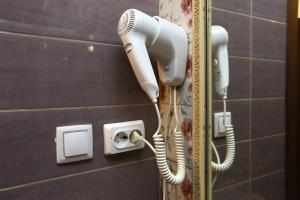 a hair dryer and a phone on a wall at Eden Hotel in Moscow