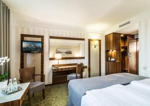 华沙华沙​​机场洛德酒店的一间配有床和书桌的酒店房间