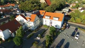 an aerial view of a large white building with an orange roof at Ferienwohnung Yachthafen Wiek in Wiek auf Rügen
