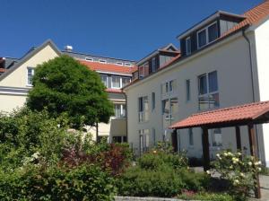 a group of buildings with trees and bushes at Ferienwohnung Yachthafen Wiek in Wiek auf Rügen