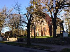 a church with trees on the side of a street at Ferienwohnung Yachthafen Wiek in Wiek auf Rügen +7 photos