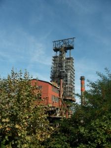 a tall building with a factory behind some trees at APARTAMENTO LABEGAIN 2 in Sestao