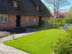 ein Haus mit einem Rasenplatz davor in der Unterkunft De Friesenjung Nordsee in Risum-Lindholm