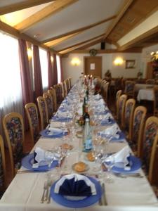 einen langen Tisch mit Tellern und Weingläsern darauf in der Unterkunft Hotel Torretta in Bellamonte