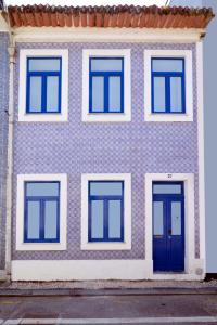 a blue and white building with blue doors at A Lodge in Blue in Aveiro