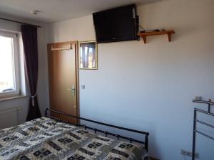オストゼーバート・カールスハーゲンにあるFewo Oase 28_GROTのベッドルーム1室(ベッド1台、壁掛けテレビ付)