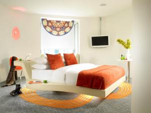 a bedroom with a bed with orange and white pillows at My Brighton in Brighton & Hove