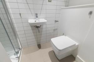 a white bathroom with a toilet and a sink at Spacious and chic flat in Angel in London