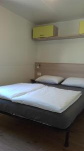 zwei Betten in einem Zimmer mit weißen Laken in der Unterkunft Mobile Home Cinzia in Pula
