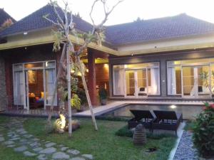 a house with a swimming pool in the yard at Villa Ketut Kartika in Ubud