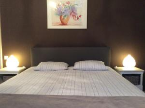 a bedroom with a bed with two lights on it at La Villa des Roses in Durbuy