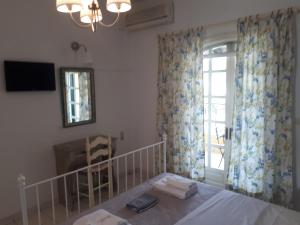a room with a table and a window and a mirror at Fofos Rooms in Syvota