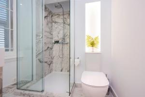 a bathroom with a toilet and a glass shower at Merchant Liston Suite in Corfu