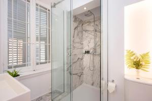 a bathroom with a shower with a glass door at Merchant Liston Suite in Corfu