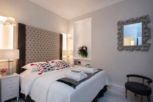 a bedroom with a bed with a mirror and a chair at Merchant Liston Suite in Corfu +10 photos