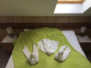 a bed with two pairs of white socks on it at CVSE Clubház és Panzió in Cegléd